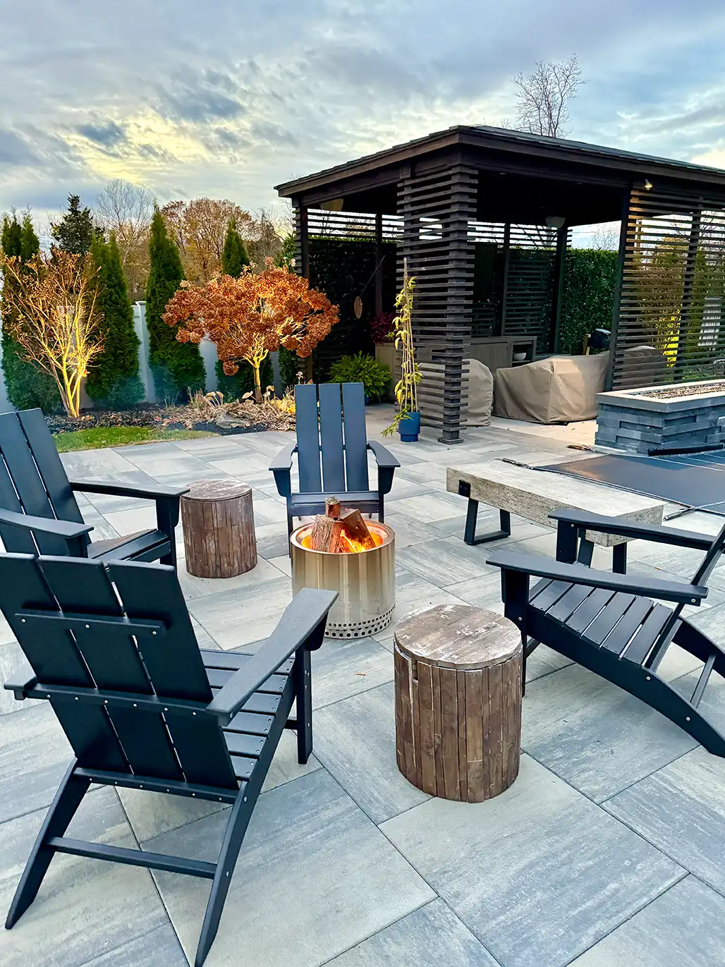 Graue keramische Terrassenplatten mit Sitzbereich und Feuerstelle