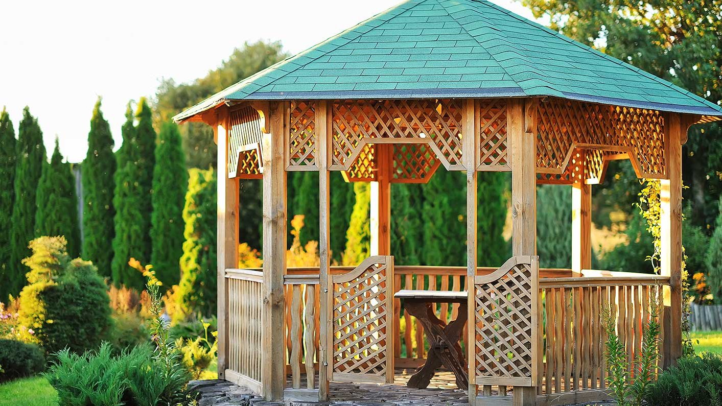 Achteckiger Holzpavillon mit Dach als überdachter Sitzplatz im Garten