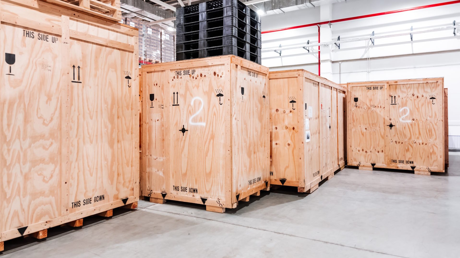 Exportkisten aus Holz für See-, Luft- und Landfracht, gestapelt in einer Lagerhalle
