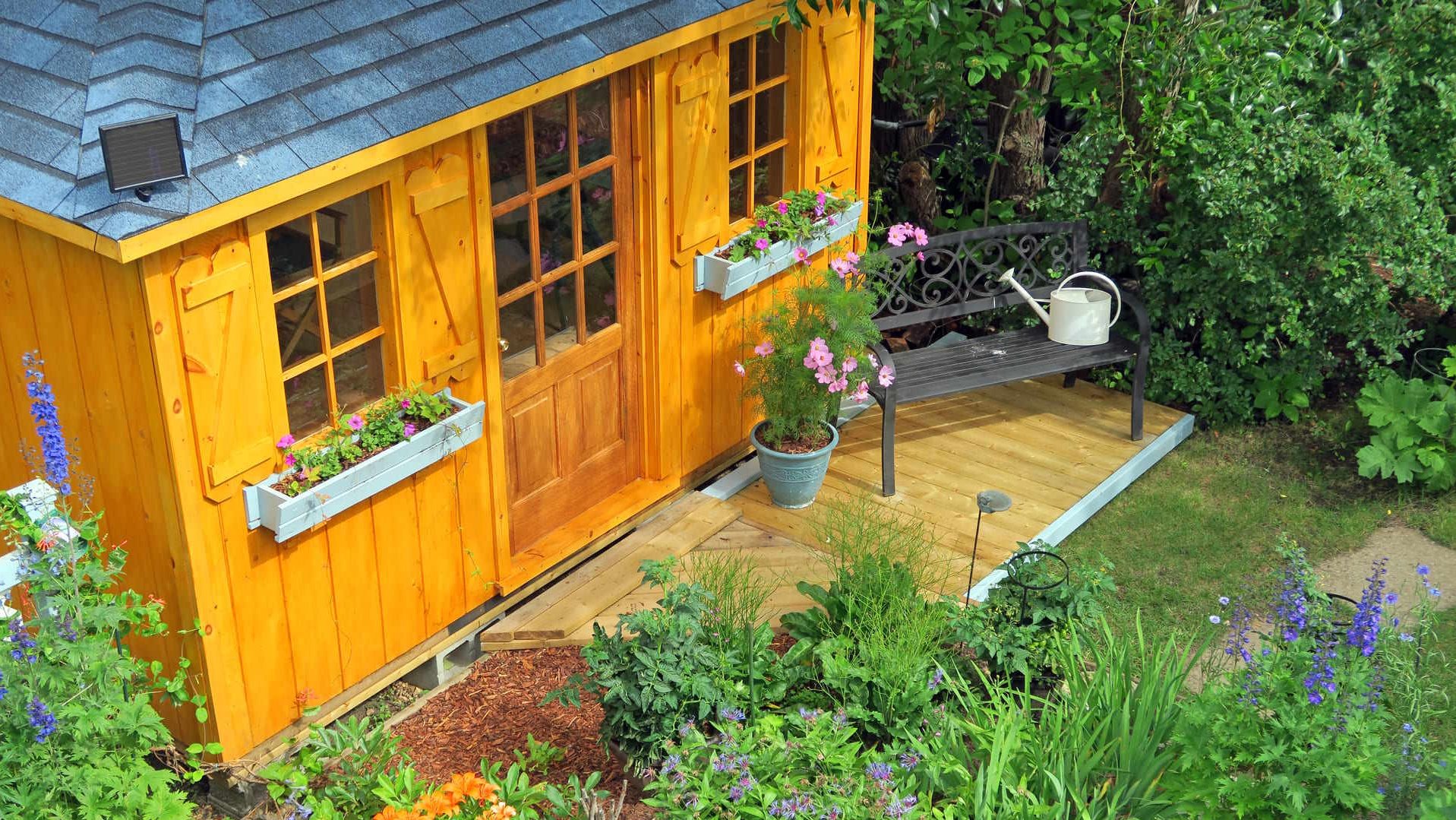 Gartenhaus aus Holz mit Fenstern und Tür in einem Garten